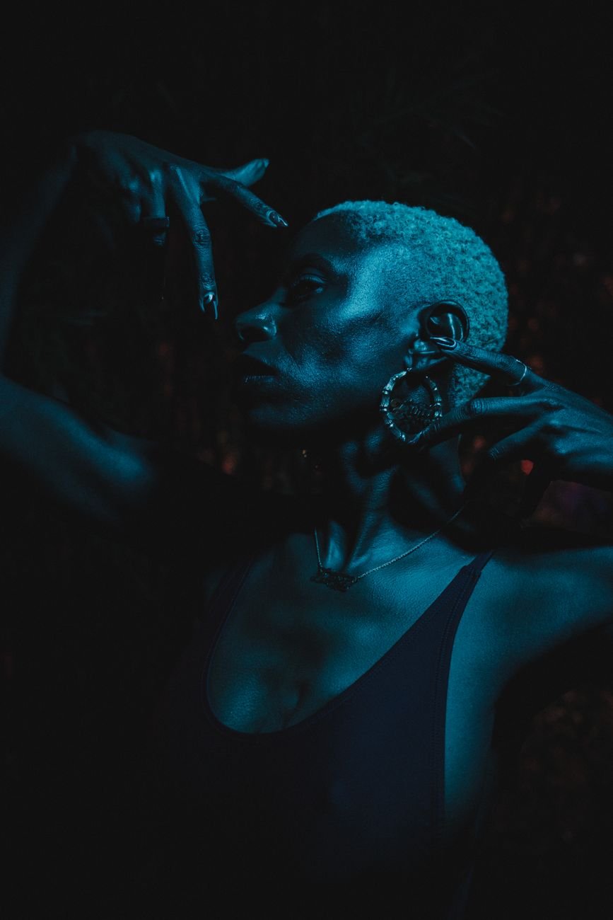 Dramatic portrait of a woman with short hair in moody blue lighting