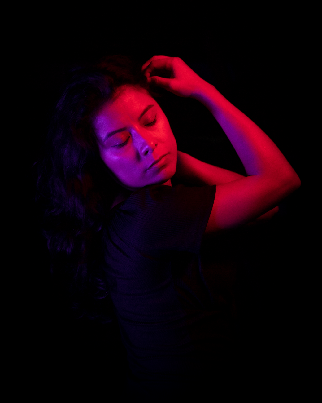 Dramatic portrait of a woman with neon pink and purple lighting